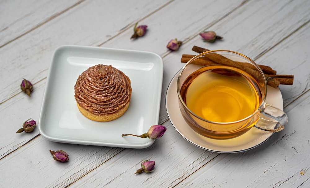 cupcake on square white ceramic plate near tea beside cinnamon