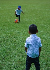 Children happily playing soccer on a colorful playground.
