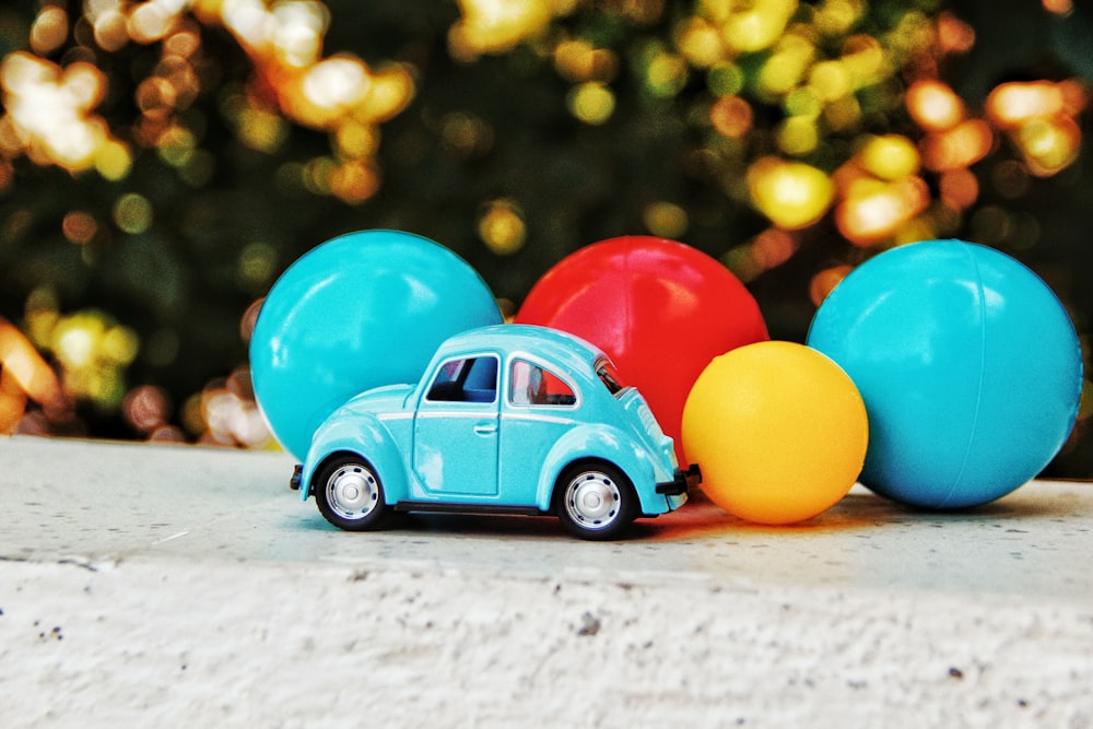 blue Volkswagen coupe toy near balloons