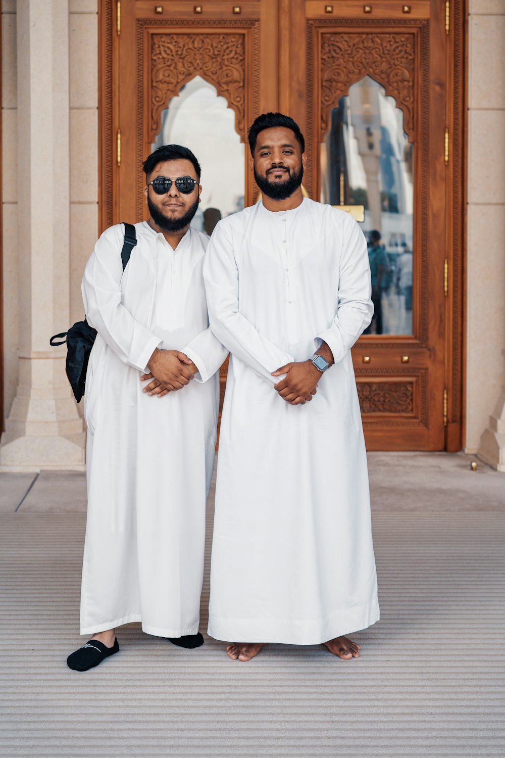 dois homens sorridentes de pé lado a lado