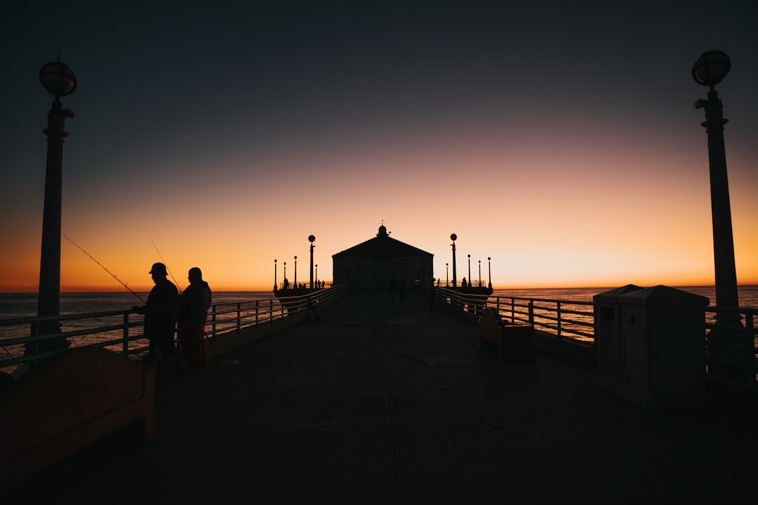 a couple of people that are standing on a pier,