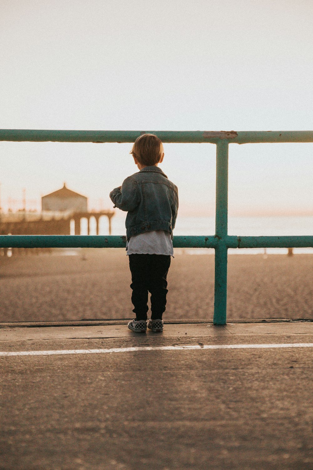 boy near fence at beach