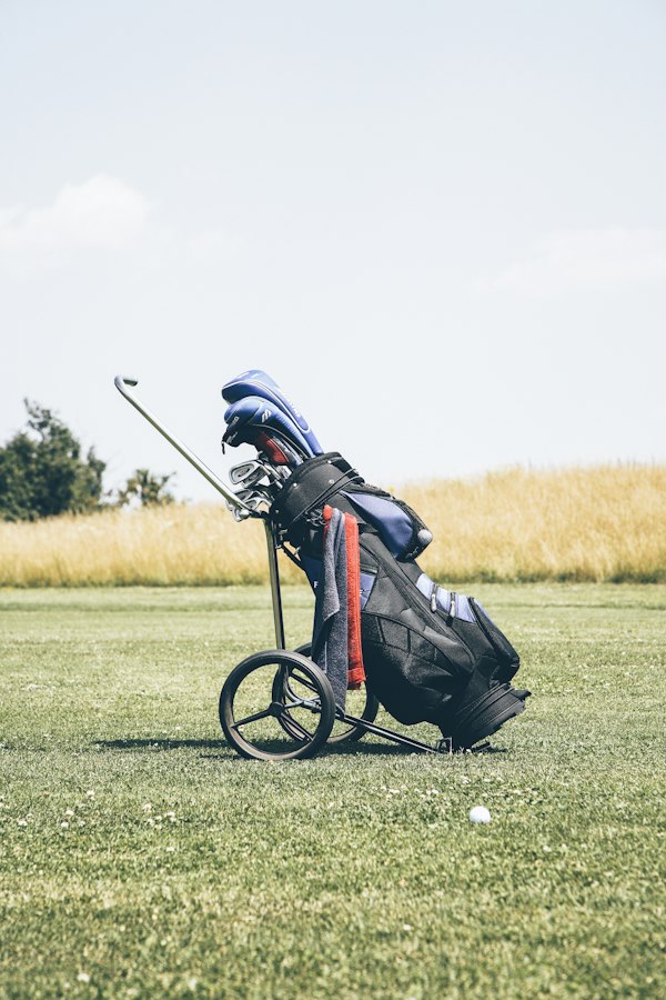 Sac de golf et clubs posés sur un practice, lumière du matin