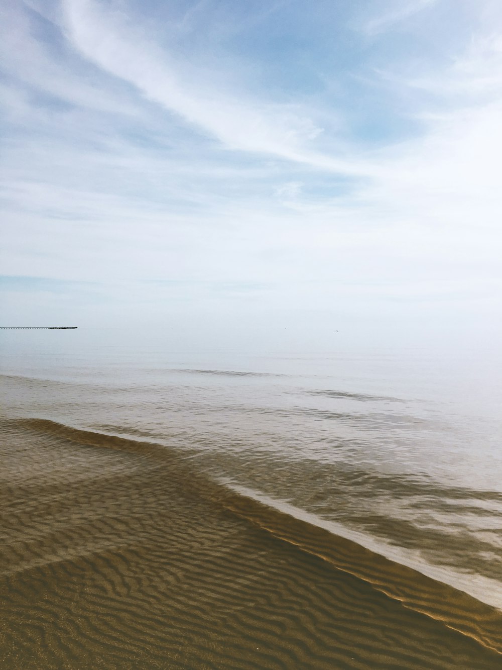 a sandy beach with a body of water in the distance