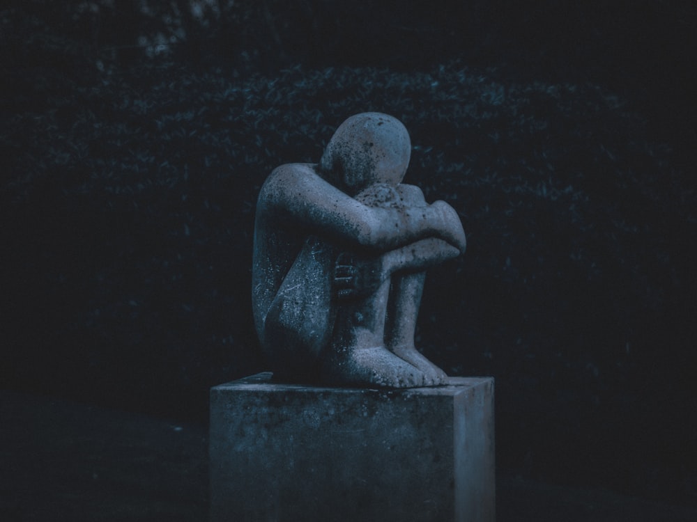 man hugging his knee statue