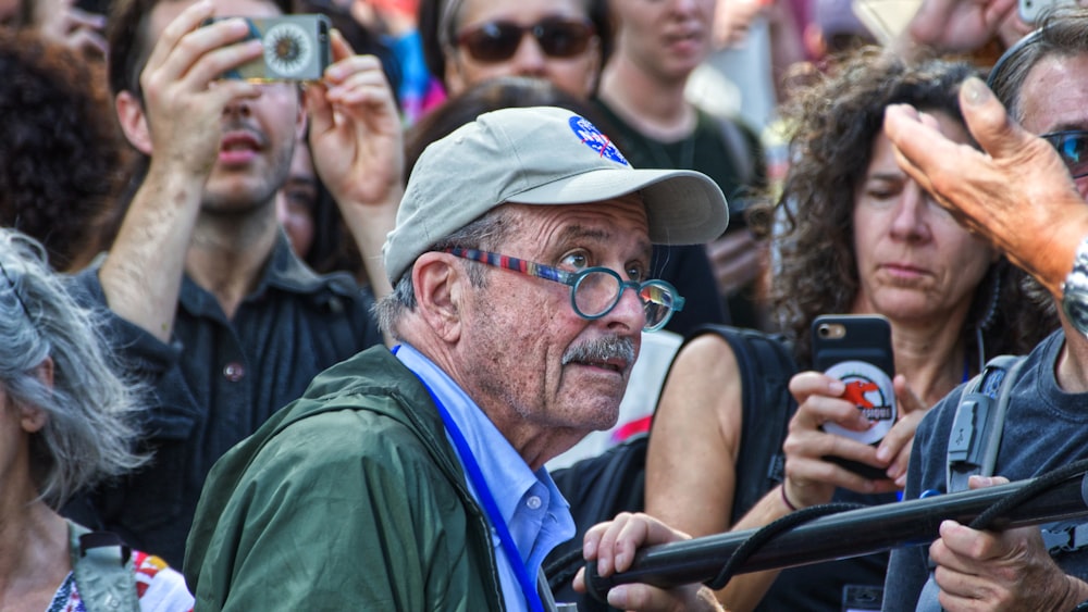 man wearing cap at middle of people