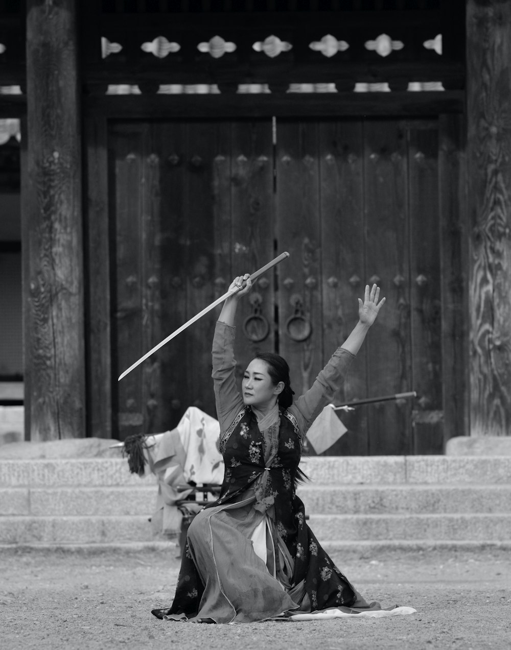 Photo en niveaux de gris d’une femme tenant une épée