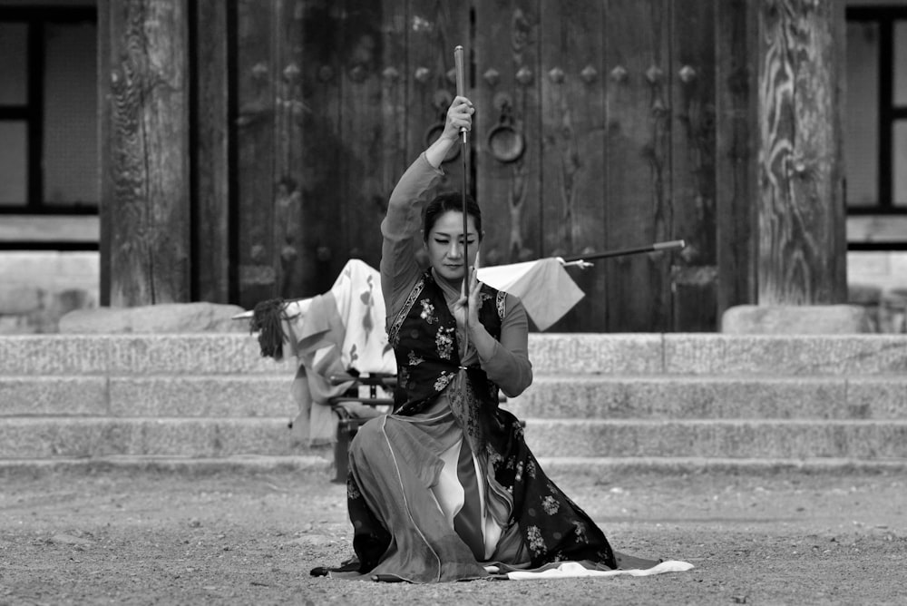 grayscale photo of woman holding sword