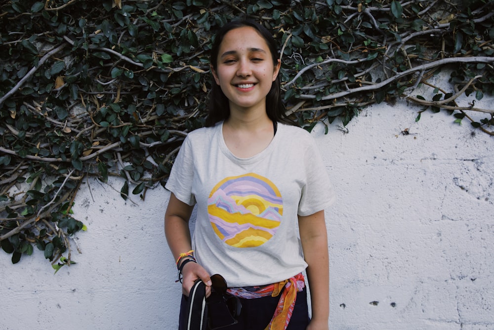 selective focus photography of smiling girl standing beside wall