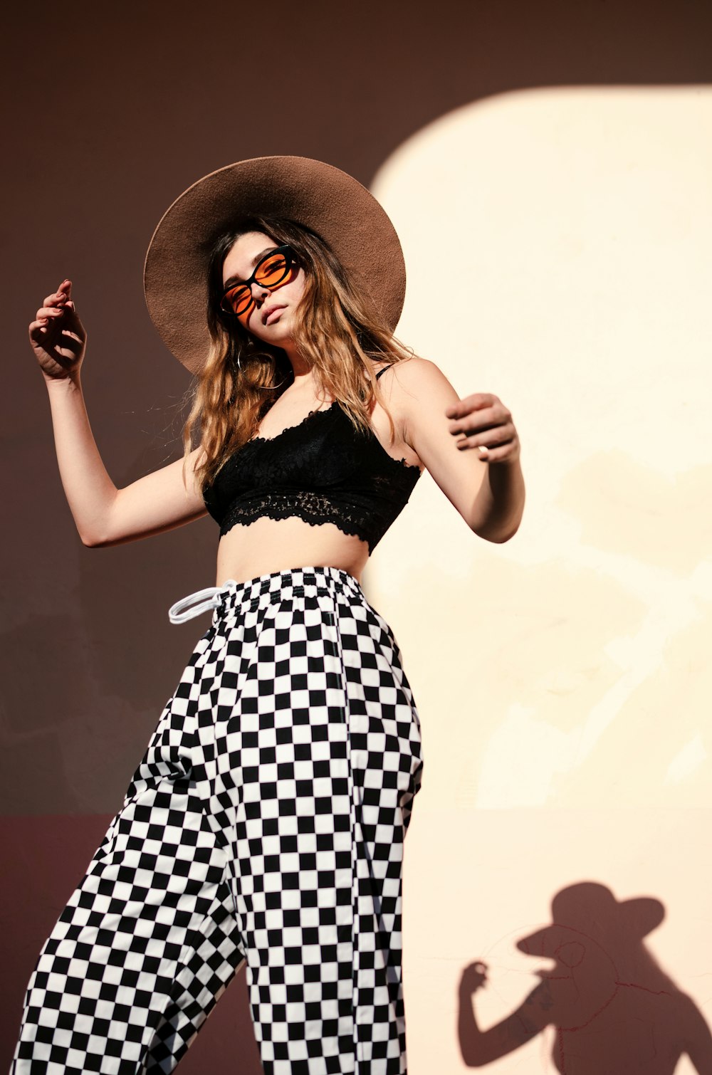 low angle photo of woman standing beside wall