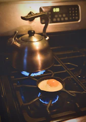A compact electric kettle steaming gently next to a breakfast setup.