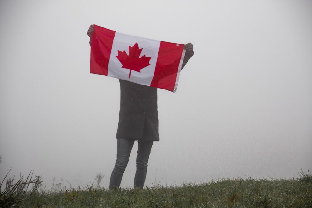 person holding flag of Canada