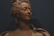 Close-up of a finely detailed 3D family portrait sculpture in elegant black and gold tones.