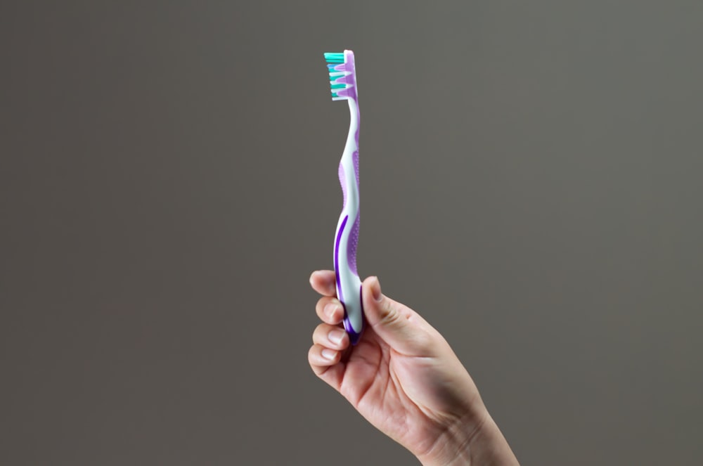 purple, green, and white toothbrush
