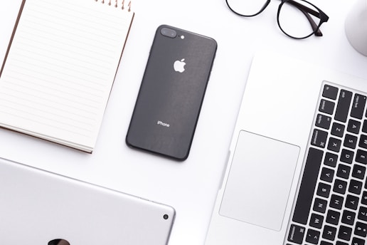 A sleek workspace set up in a well-decorated apartment with a laptop and notepad.