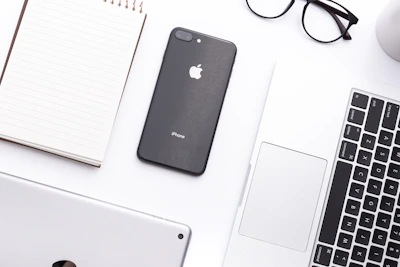 A sleek workspace with minimalist black and white decor, featuring a laptop and marketing materials neatly arranged.