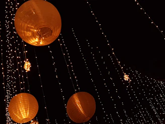 Colorful strings of fairy lights and lanterns hanging against a backdrop of a festive home setting.