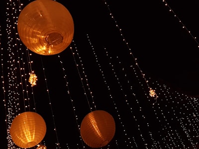 Festive garden lights glowing warmly across a backyard in the evening.