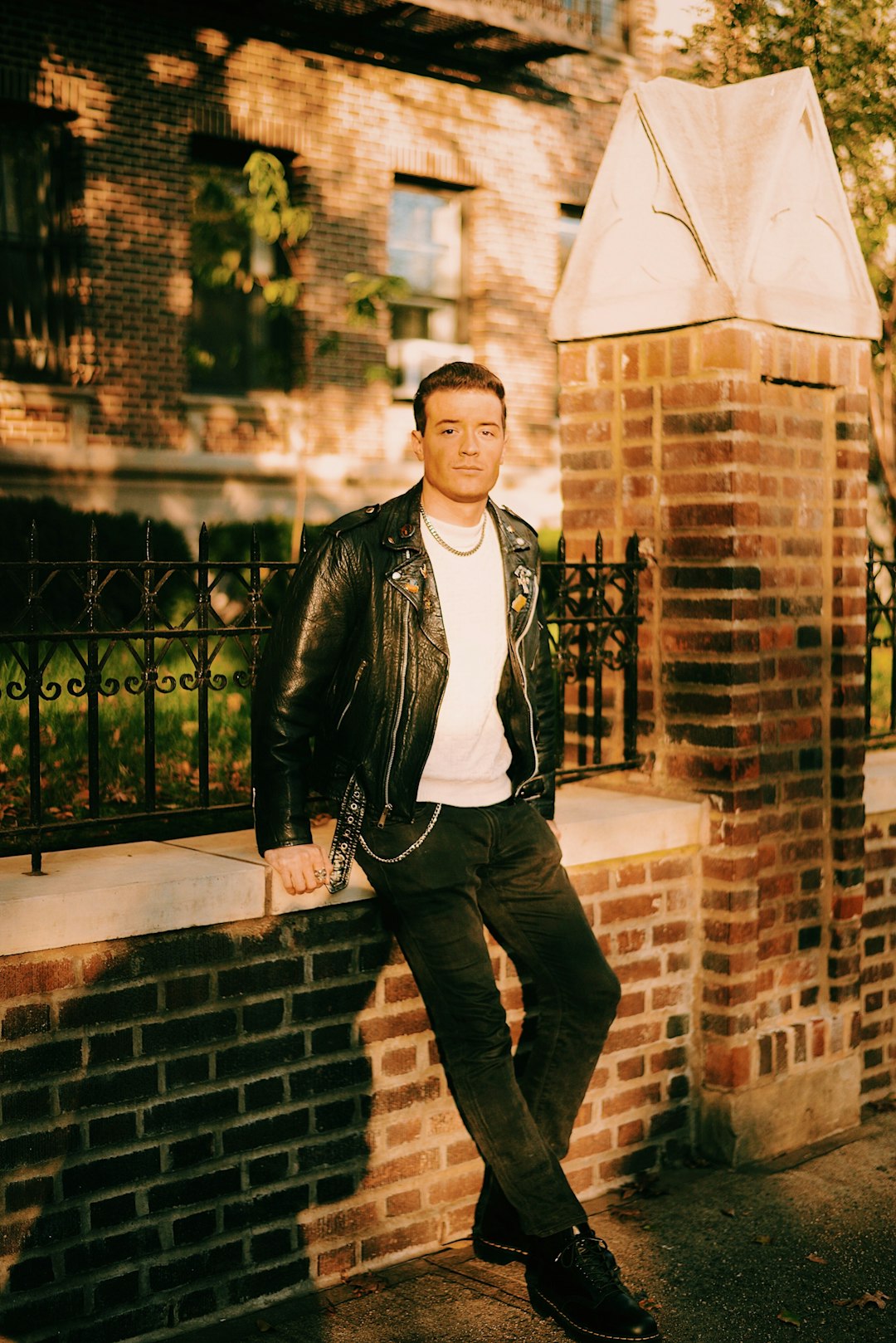 man leaning on concrete brick fence