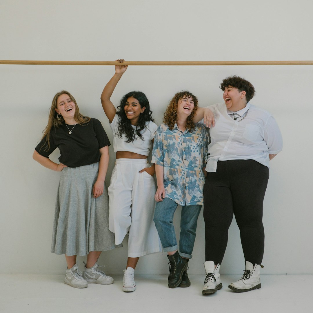 four person standing beside wall