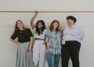 four person standing beside wall