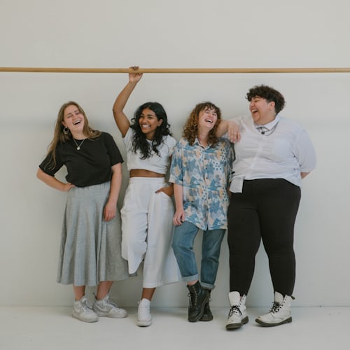 Un groupe de quatre jeunes femmes posant pour une photo afin d'illustrer les légendes de Instagram pour leurs amis. 