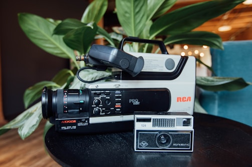 A warm scene showing a vintage video camera on a wooden desk with soft natural light.