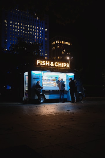 group of people standing on Fish & Chips store