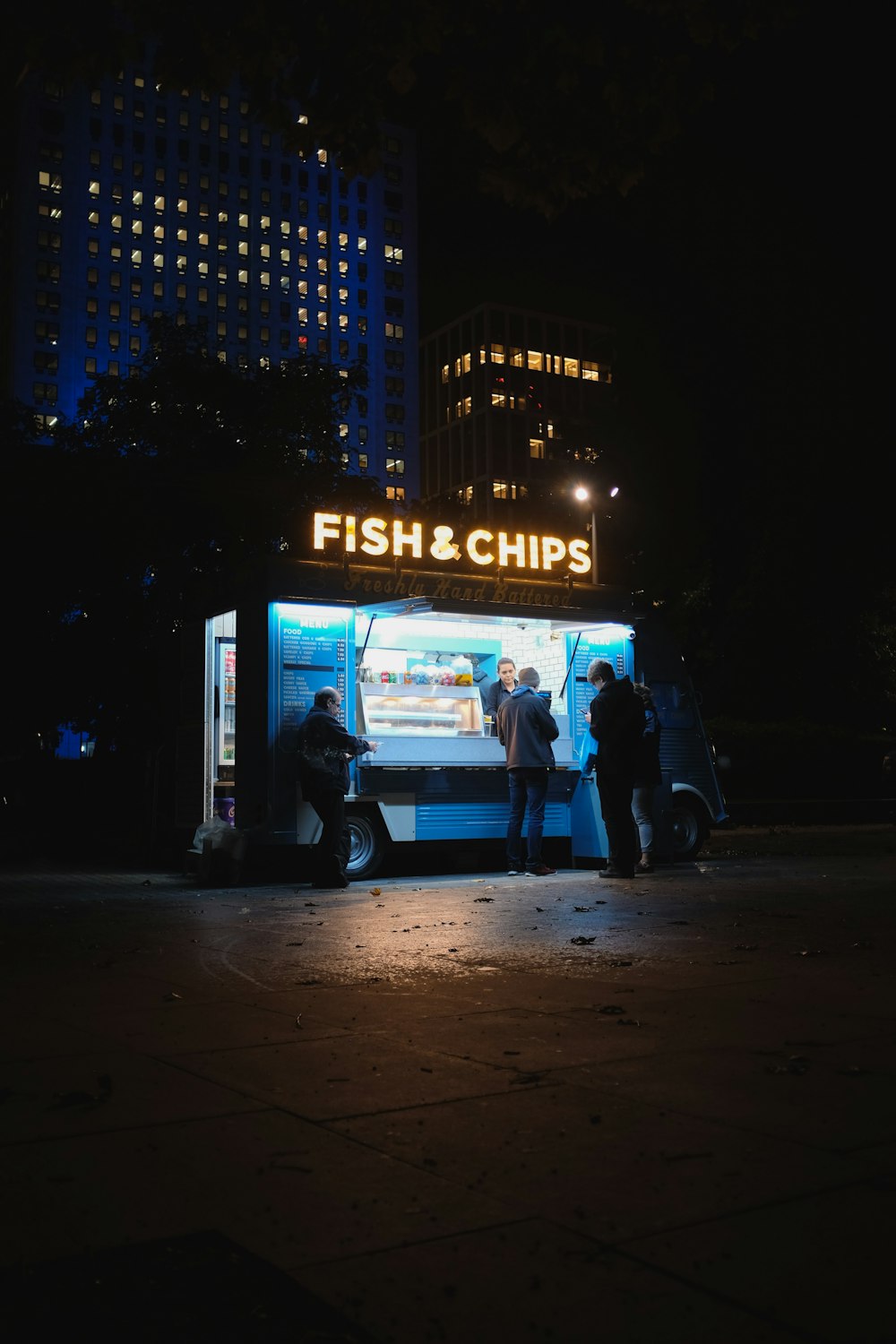 gruppo di persone in piedi sul negozio Fish & Chips
