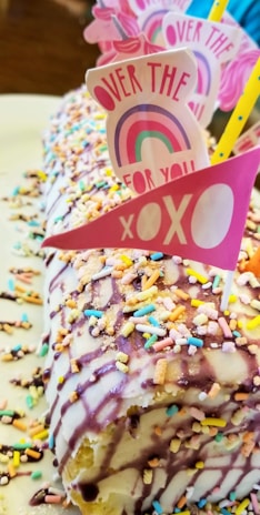 A vibrant celebration cake featuring colorful buttercream rosettes and playful sprinkles.