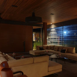 A cozy seating area with navy blue cushions and soft orange lighting for guests to relax.