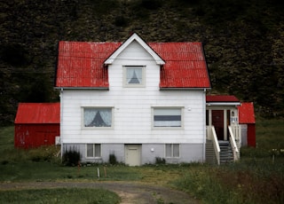 white and red 2-storey house near trees