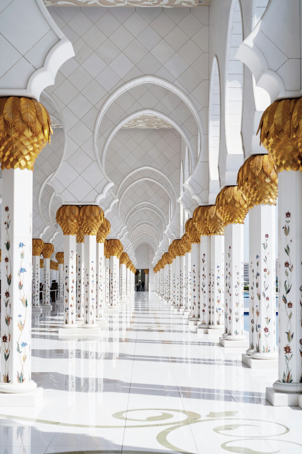 a white and gold building with columns and arches