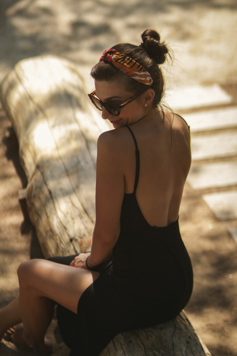 woman sitting on brown log