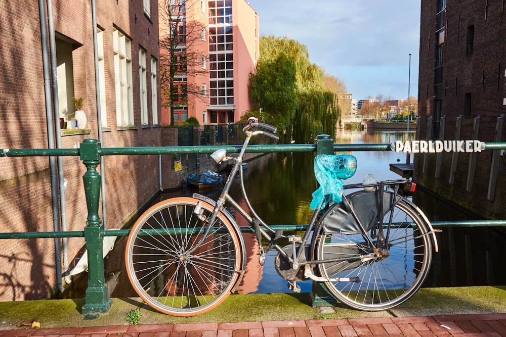 black road bike parked on green metal railway