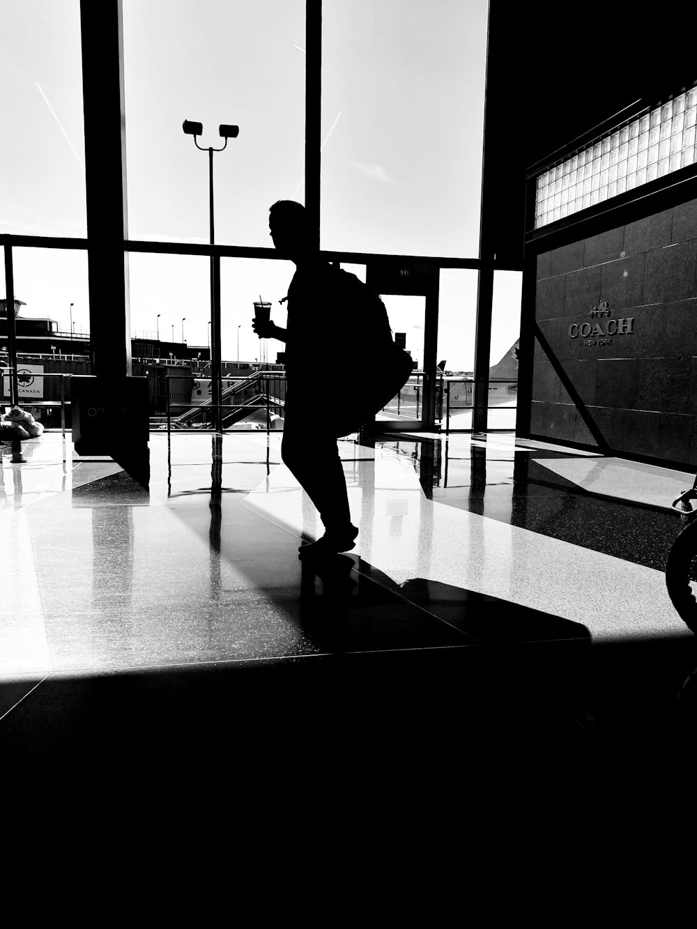 silhouette of man walking on sidewalk