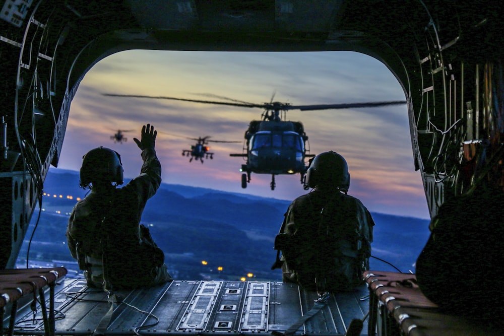 two soldiers on flying airplane with strap on back