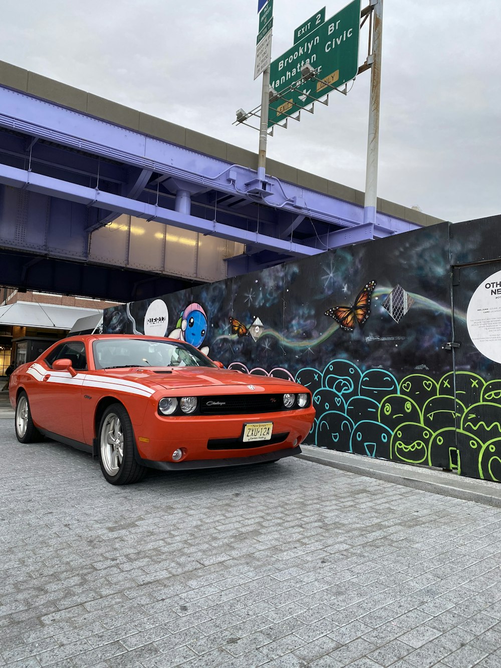 red Dodge Challenger parked beside wall