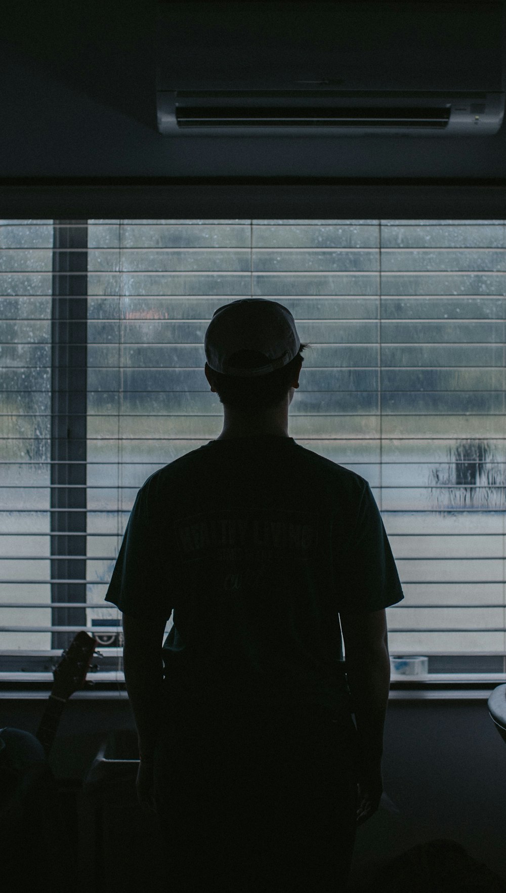 man standing in front of window looking outside