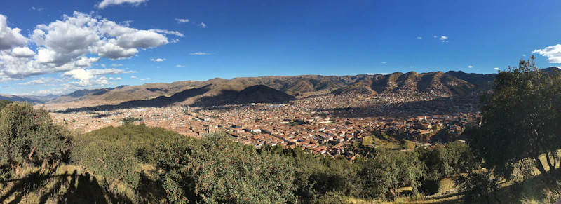 Aerial panorama of Cusco filling the valley below the surrounding hills