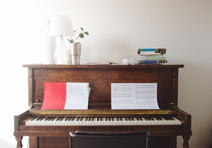 Aufrechtes Klavier mit Notenblättern in einem hellen Wohnzimmer