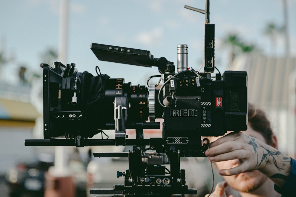 person using black professional video camera