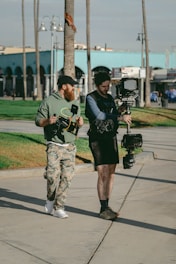 two men carrying filming camera