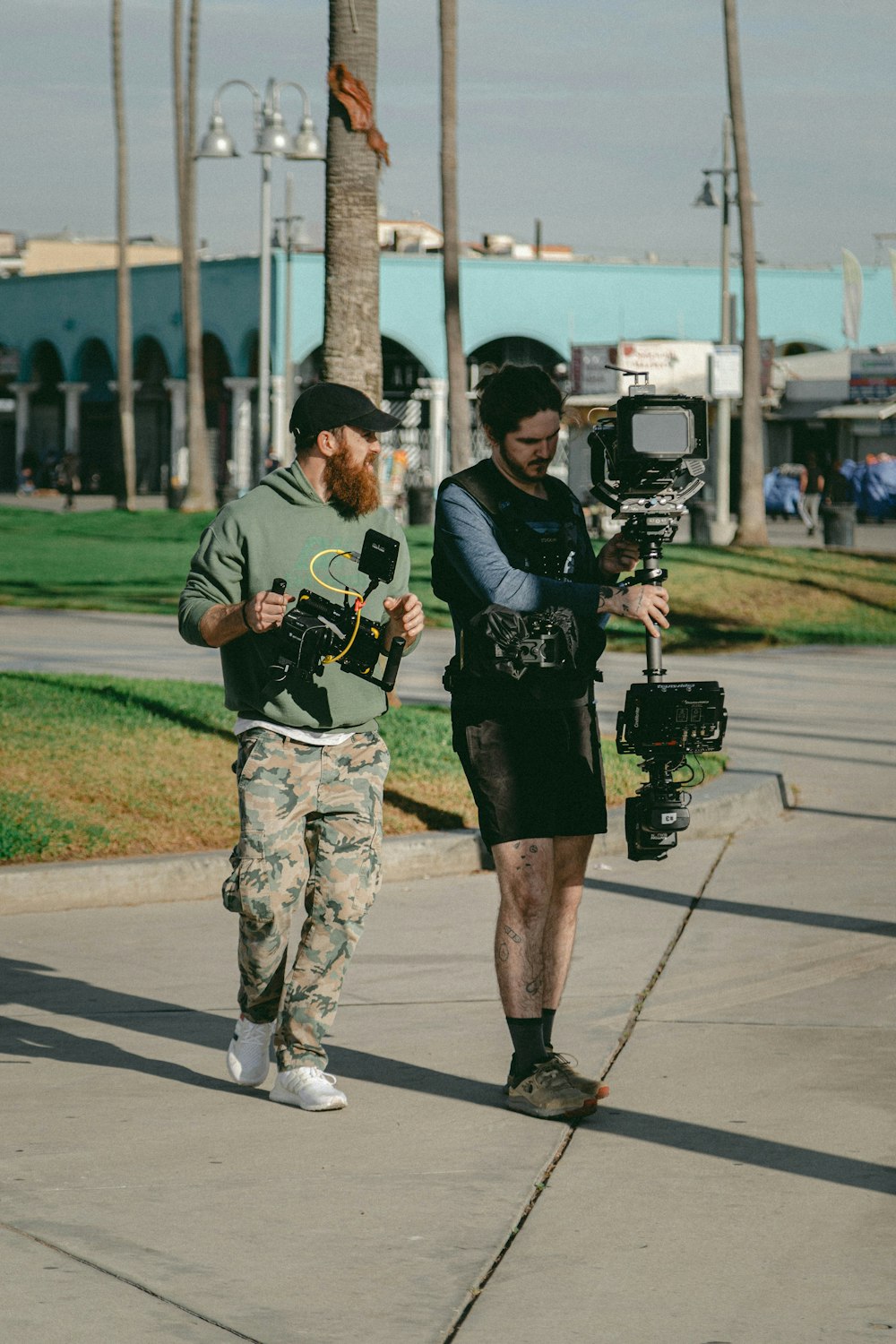 two men carrying filming camera