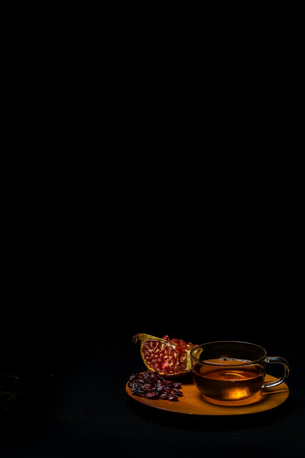 teaglass on tray beside pomegranate