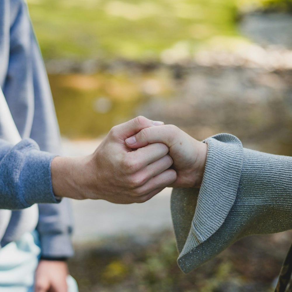 Un hombre y una mujer tomados de la mano mientras están de pie uno al lado del otro