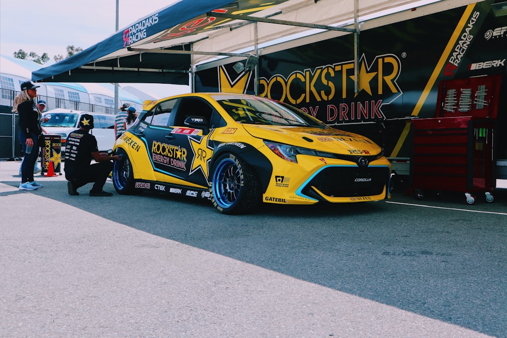 yellow and black vehicle parked beside wall