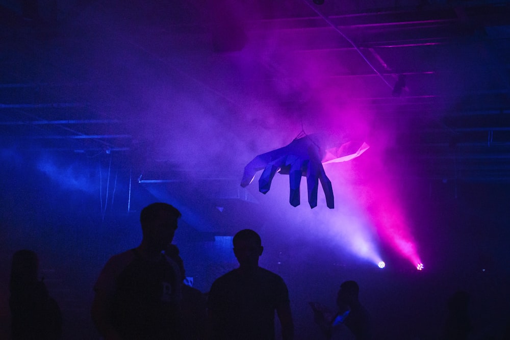 a person's hand hanging from the ceiling of a dark room