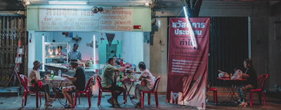 Happy customers enjoying meals around a cozy outdoor food stall.