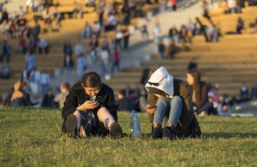 Parents and players checking schedules on their phones at the field